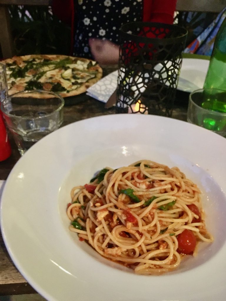 Crab spaghetti with pizza in background