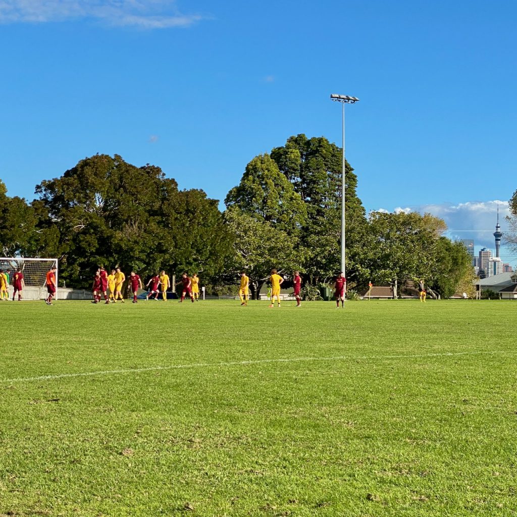 Men playing football under blue sky